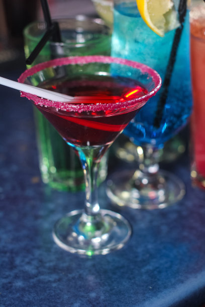 美味的创意明亮的鸡尾酒酒精与吸管是在一个俱乐部或一个照明酒吧的桌子上图片下载