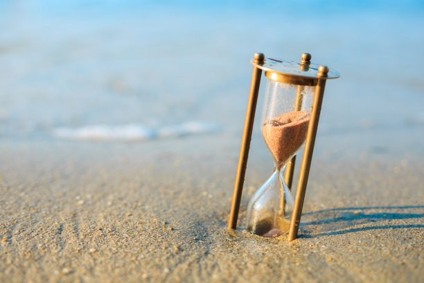遗失在海滩上的古董沙漏。海边的旧表。图片下载