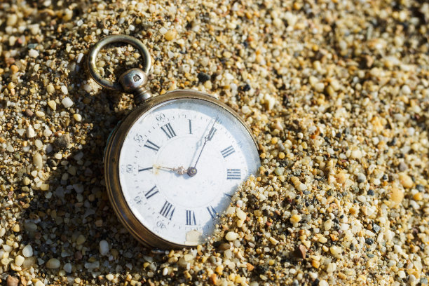 埋在沙子里的怀表。旧表掉在沙子里了。图片下载