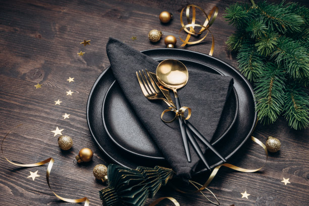 圣诞餐桌上的黑色盘子和金色装饰图片下载