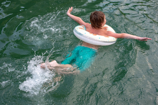 一个婴儿游泳，一个救生圈和一个婴儿。海边的夏日照片图片下载