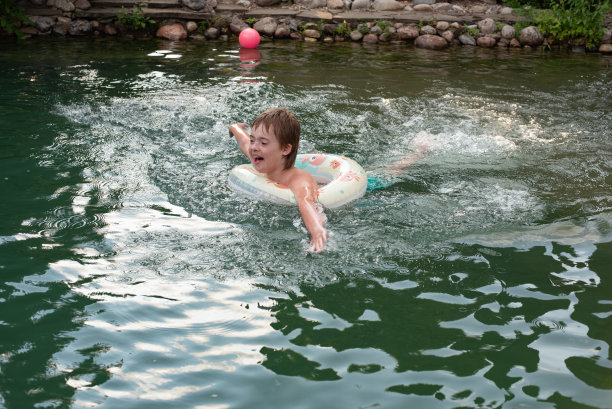 一个婴儿游泳，一个救生圈和一个婴儿。海边的夏日照片图片下载
