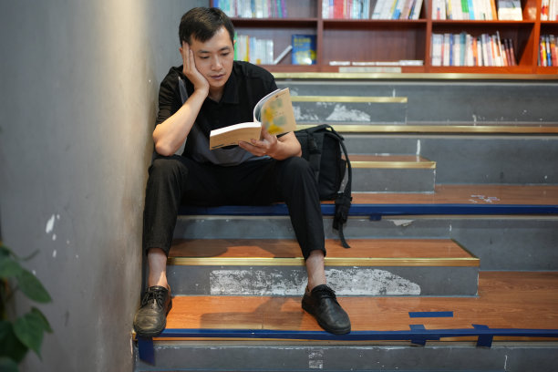 一个男孩正在读书以增加他的知识。图片下载