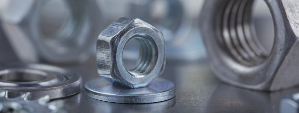 在钢板背景上设置不同的螺母，螺栓，螺钉，垫圈和钻头，丝锥和铣刀。锁匠工作协议。图片下载