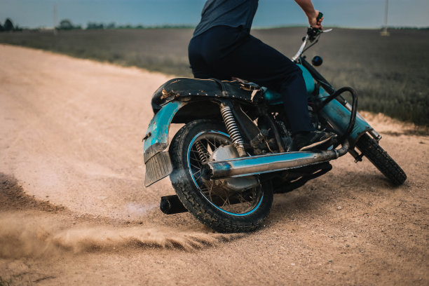 摩托车手骑着复古摩托车在沙道上漂移，进行摩托车越野训练。图片下载