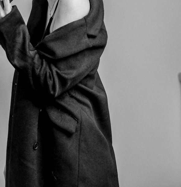 一位身穿吊带裙和风衣的优雅女性的灰度照片图片下载