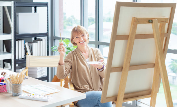 艺术学校。创造力和人的观念。快乐的高级女艺术家与画架和铅笔画的图片在工作室图片下载