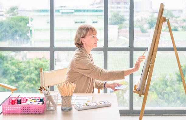 艺术学校。创造力和人的观念。快乐的高级女艺术家与画架和铅笔画的图片在工作室图片下载