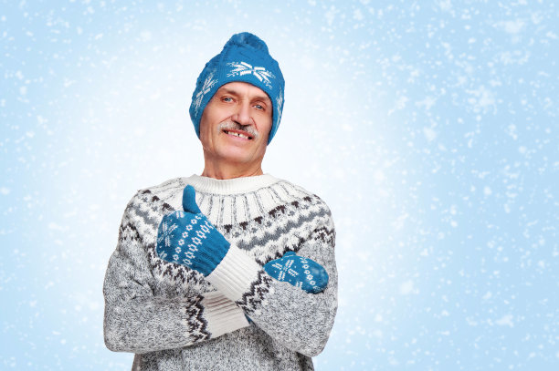 戴着蓝色帽子和手套的男子在蓝色背景下竖起大拇指图片下载