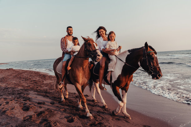 一家人和孩子们一起在沙滩上骑马。有选择性的重点图片下载