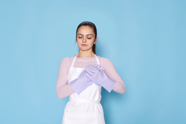 戴着橡胶手套的漂亮女人，手放在胸前图片下载