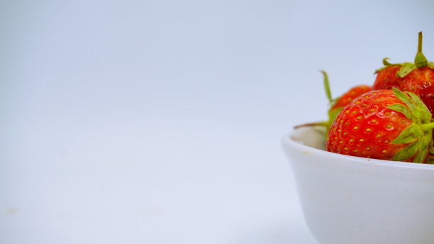 新鲜成熟的美味草莓放在白色的碗里图片下载