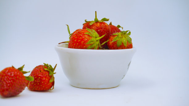新鲜成熟的美味草莓放在白色的碗里图片下载