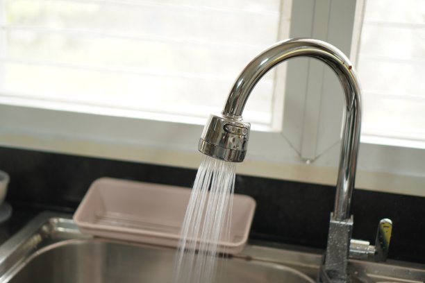 这张照片显示的是从厨房水槽的水龙头流出的水，特写。图片下载