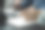 男人拿着笔在笔记本上写字，笔记本电脑在桌子上。图片下载