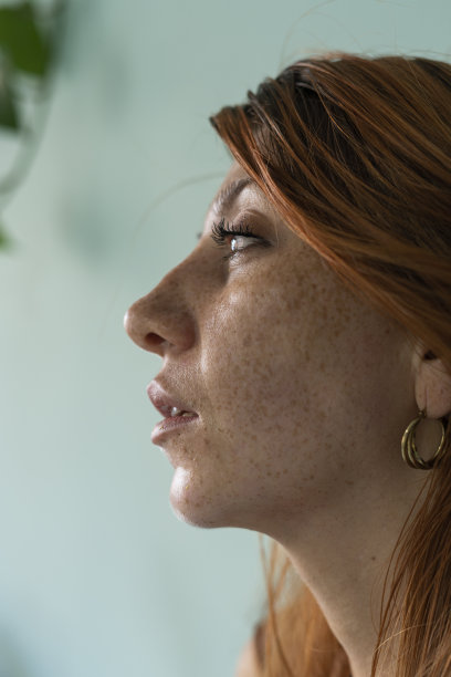 一位平均年龄25岁、红头发、脸上有雀斑的拉丁裔女性在家中拍摄面部照片图片下载