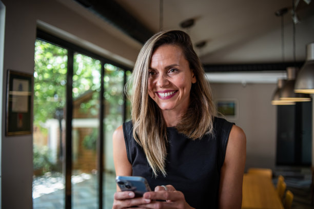 一位女商人站在餐厅里用手机图片下载