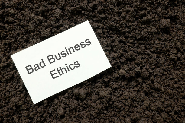 商业观念中的不道德行为或不良道德规范。一张写有手写便条的纸，放在深色的泥土上。图片下载