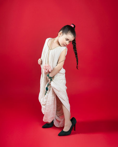 穿高跟鞋的黑头发时尚小个子。有趣的照片拍摄在工作室的红色背景图片下载