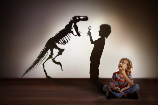 恐龙的影子在孩子的梦里。孩子们读,想象图片下载