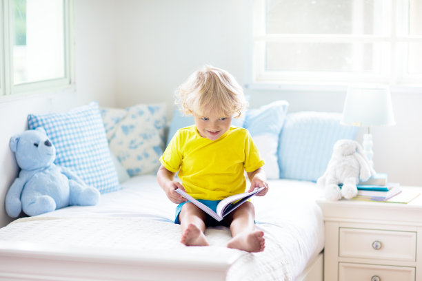 孩子在床上玩耍。孩子的房间。小男孩在家里。图片下载