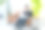 一个20多岁的男人一边在客厅沙发上用笔记本电脑工作，一边给植物看叶子图片下载