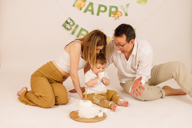 快乐的家庭用室外的生日蛋糕庆祝宝宝的第一个生日图片下载