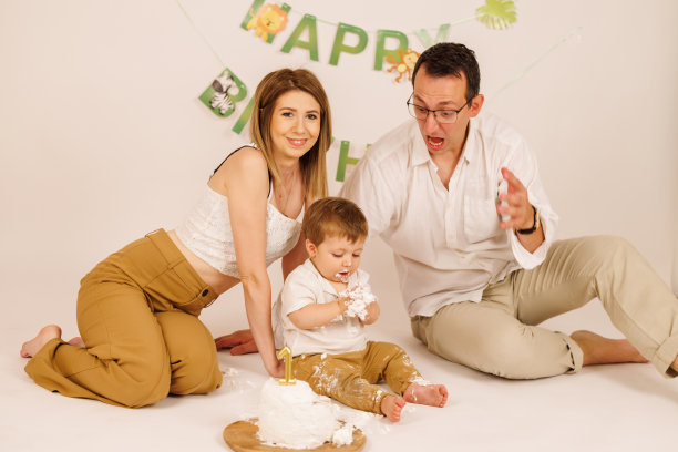 快乐的家庭用室外的生日蛋糕庆祝宝宝的第一个生日图片下载