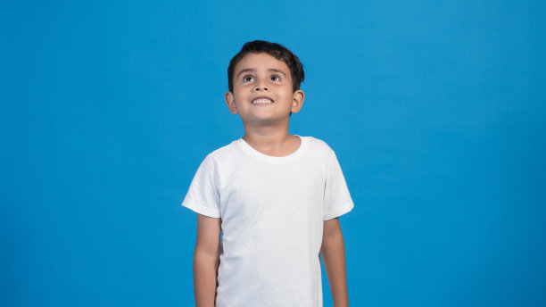 快乐的孩子，蓝色的背景，向上看图片下载