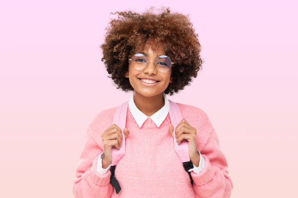 漂亮的非洲少女肖像，高中生卷曲的非洲发型和粉红色的背包图片下载