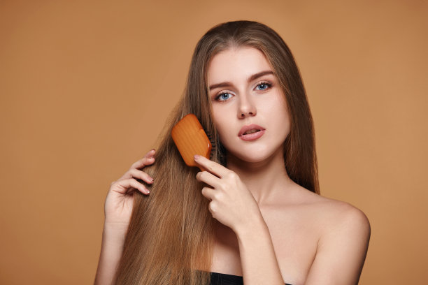 女人用木梳子梳理她自然的长发图片下载