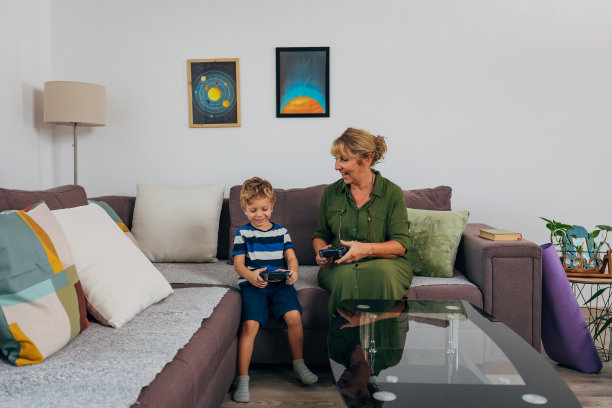 前视图的祖母和孙子玩电子游戏的乐趣与操纵杆图片下载