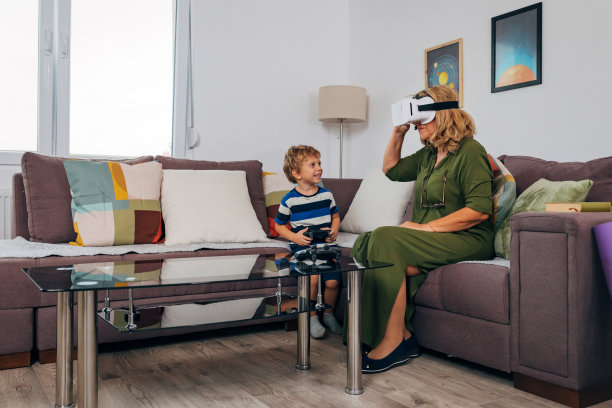 小男孩很兴奋很高兴，因为他正在和他的奶奶玩电子游戏图片下载