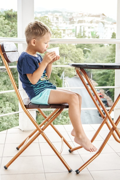 学龄前男孩在清晨喝一杯热牛奶图片下载