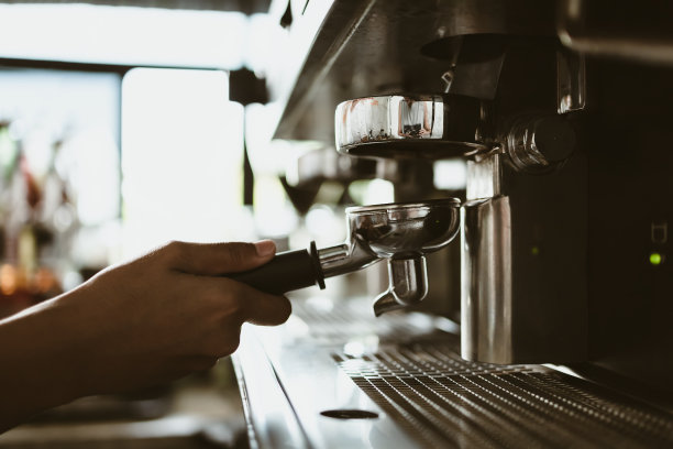 咖啡师使用有无底过滤器的咖啡机。咖啡机的概念。图片下载
