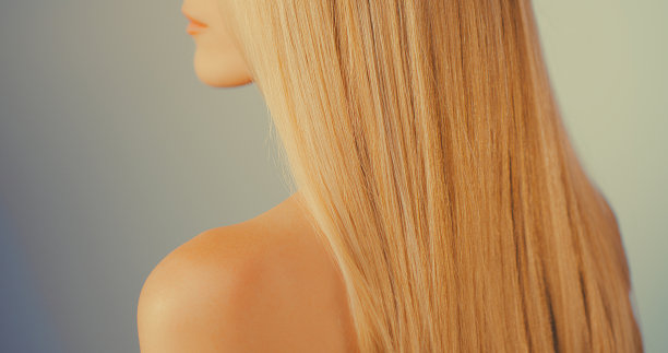 美丽，诱人的金发女人在明亮的背景。展示亮金色健康的头发图片下载