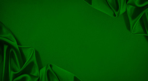 绿色的丝缎。美丽柔软的褶皱。闪亮的织物。豪华背景，空间设计。圣诞节。图片下载