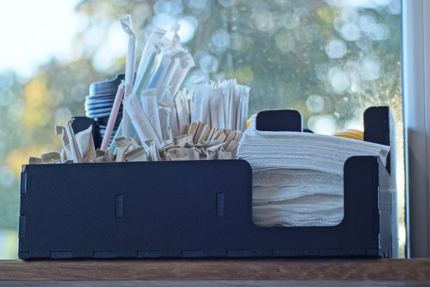 一个黑色的纸盒，里面有一套白色的餐巾纸和糖棒图片下载