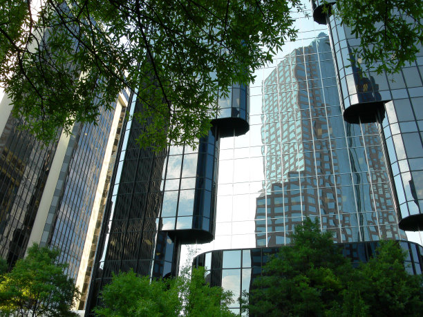 黄昏时分的超现代建筑，结构的玻璃立面反射出天空和周围环境。图片下载