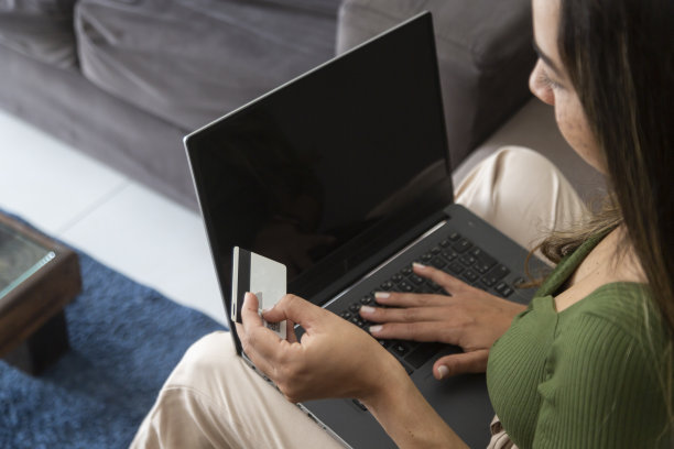 一位拉丁妇女在家用信用卡在网上购物图片下载