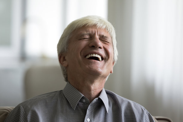 特写镜头，老人在诙谐的笑话中大笑图片下载