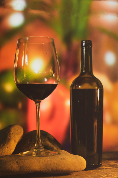 一个镶嵌在石头上的水晶酒杯，配上彩色灯光和魅力的行李箱桌上的一瓶葡萄酒，分享一个充满味道和乐趣的愉快时刻图片下载