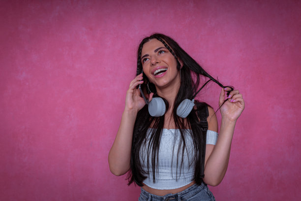 一个快乐的现代年轻女子的摄影镜头。粉红色的背景概念。图片下载