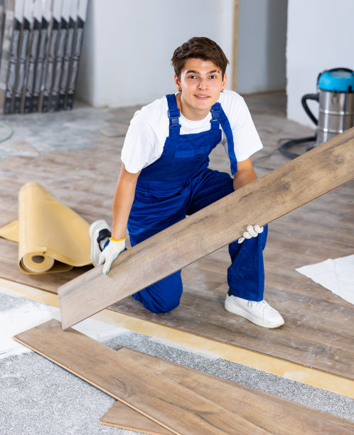 年轻的木匠在室内装修工作中铺设强化地板图片下载