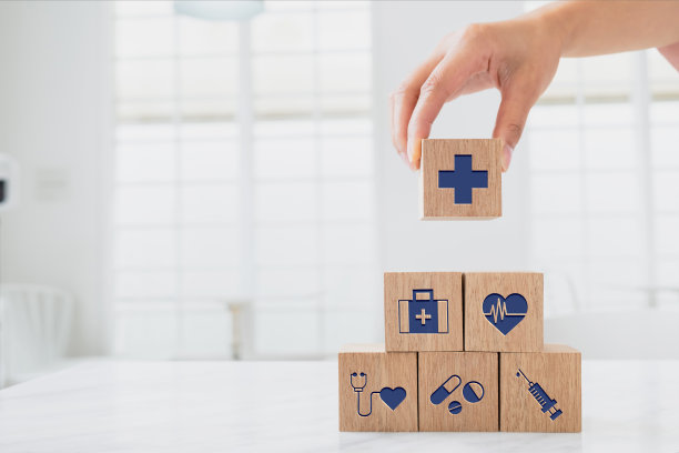 妇女手持木制块图标保健堆叠。健康和医疗保险概念。图片下载