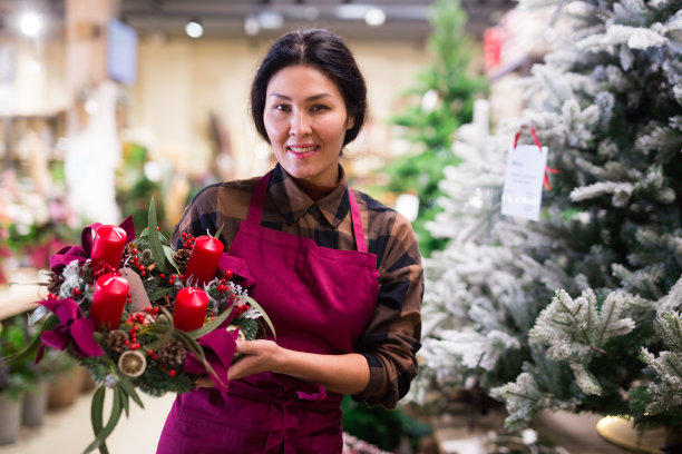 销售圣诞装饰品的亚洲女售货员图片下载