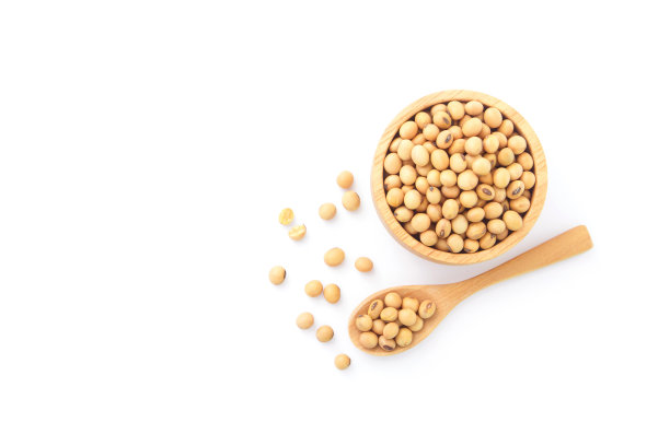 在木碗大豆种子与勺子隔离在白色背景。图片下载