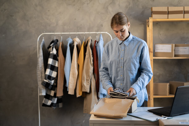 网上商店为妇女，小企业主企业家卖家，包装包装准备包订单在桌上。电子商务中的Dropshipping delivery。图片下载