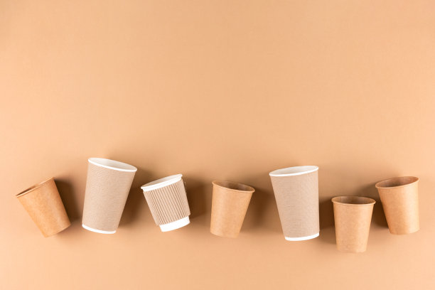 许多纸咖啡杯在浅棕色背景与复制空间。热饮料的环保纸杯将不复存在。可持续的外卖食品包装理念。以上观点图片下载