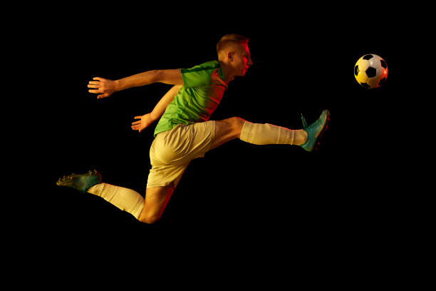 运动在行动。一名职业足球运动员在训练中把足球隔离在霓虹灯滤镜的黑暗背景下。运动，速度，力量和能量图片下载
